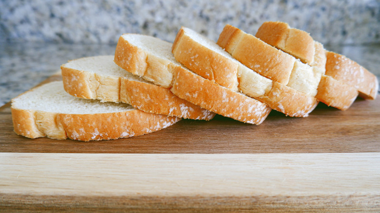 Slices of white bread on wood cutting board