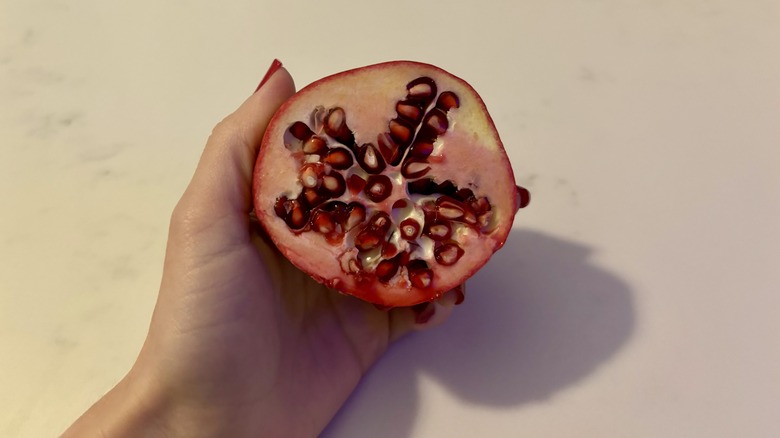 Hand holding pomegranate half