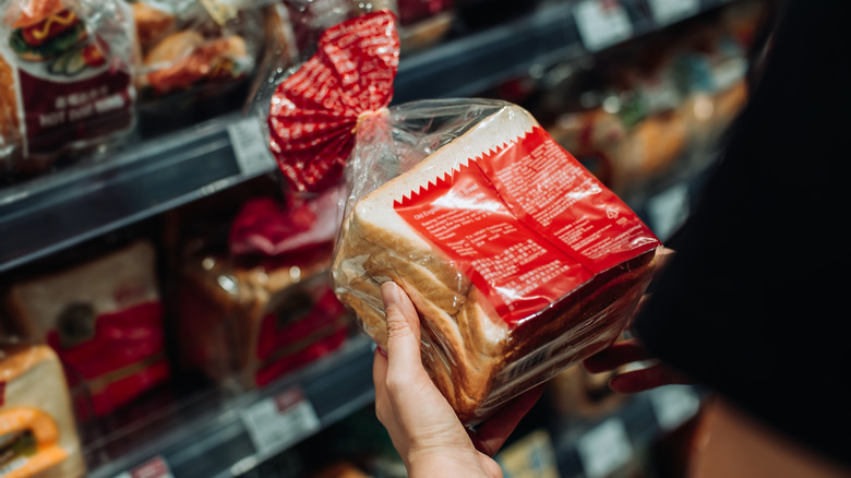 Hand holds a package of bread