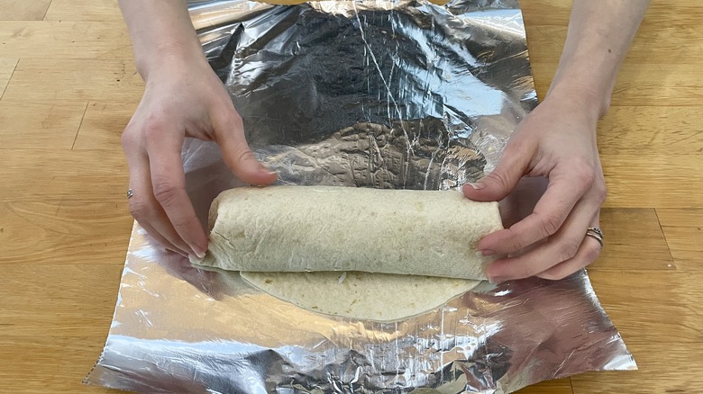 Burrito being rolled on foil