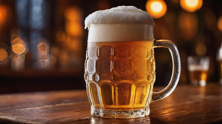 Full beer mug with a thick layer of foam on bar