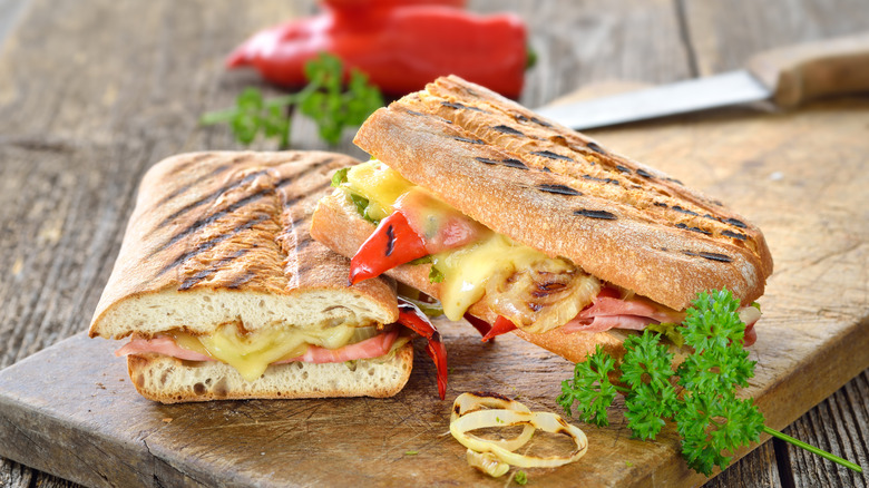 Grilled panini sandwiches on wooden board and table