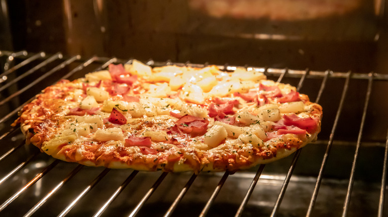A frozen pizza bakes on a rack in the oven.