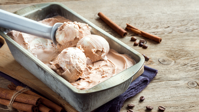 cinnamon ice cream being scooped out of a metal container