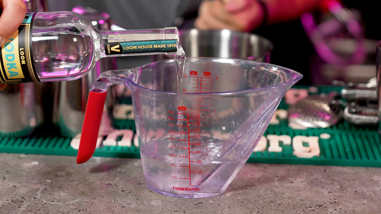 Pouring vodka into measuring cup