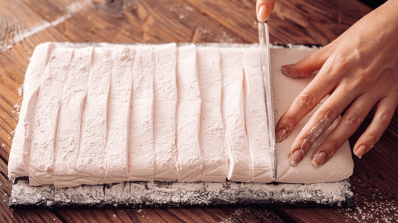 Slicing homemade marshmallows on a cutting board