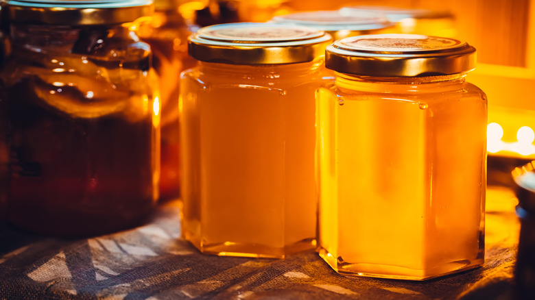 Jars of honey on wooden table