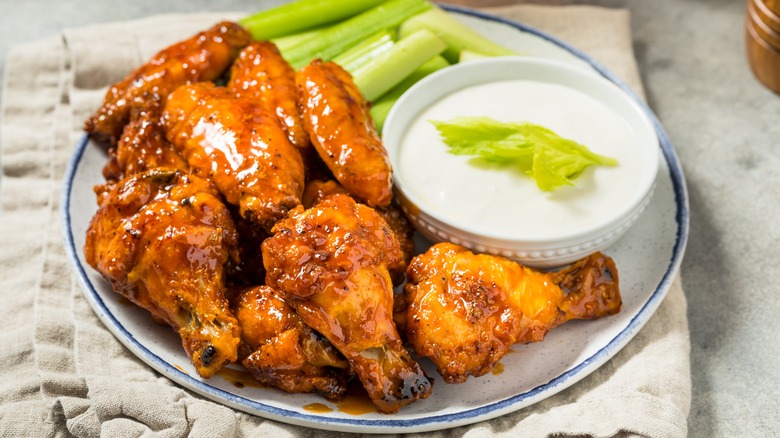 A plate of Buffalo chicken wings with bleu cheese dressing and fresh celery