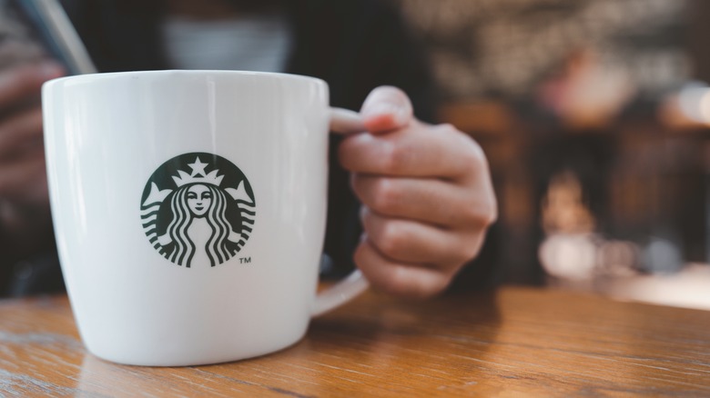 Person holding a Starbucks mug