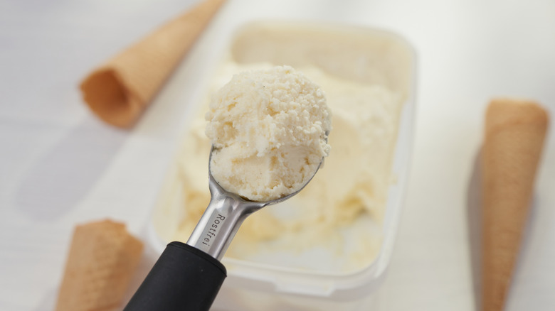 A container of vanilla ice cream with a scoop