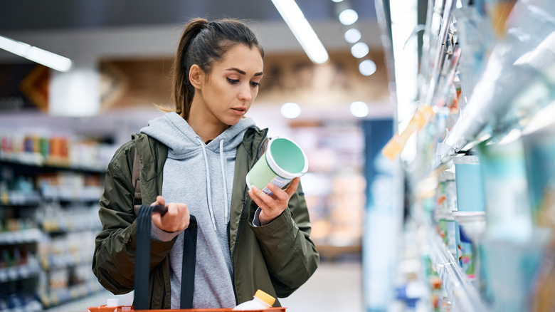 Woman examining yogurt at a store