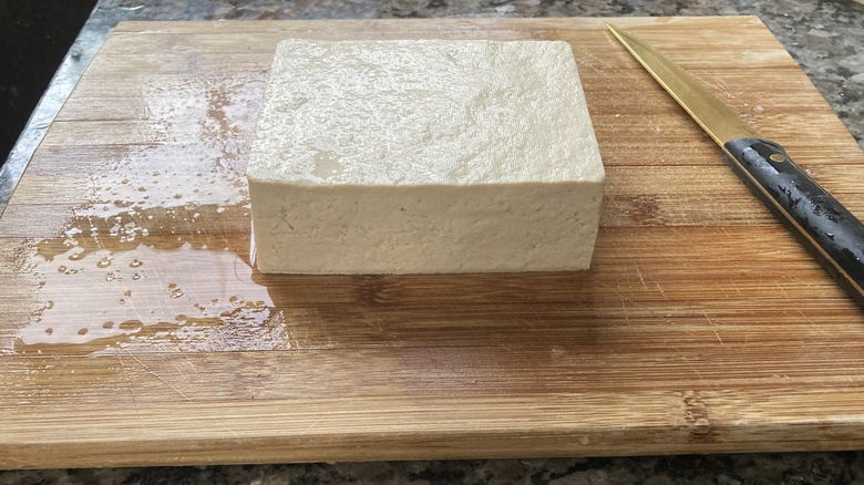 Tofu block on cutting board