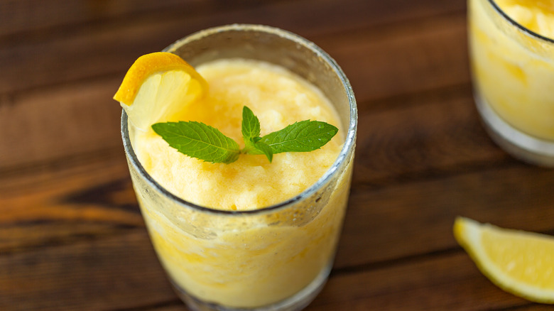 Lemon slushy drink topped with lemon slice and mint