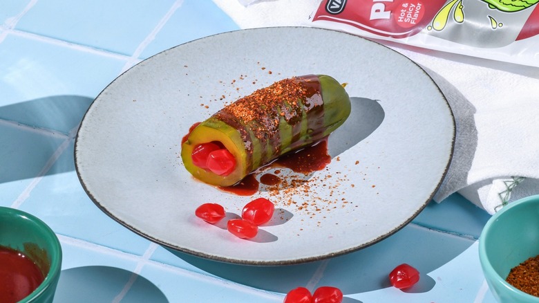 Pickle covered in chamoy and Tajin seasoning, filled with gushers