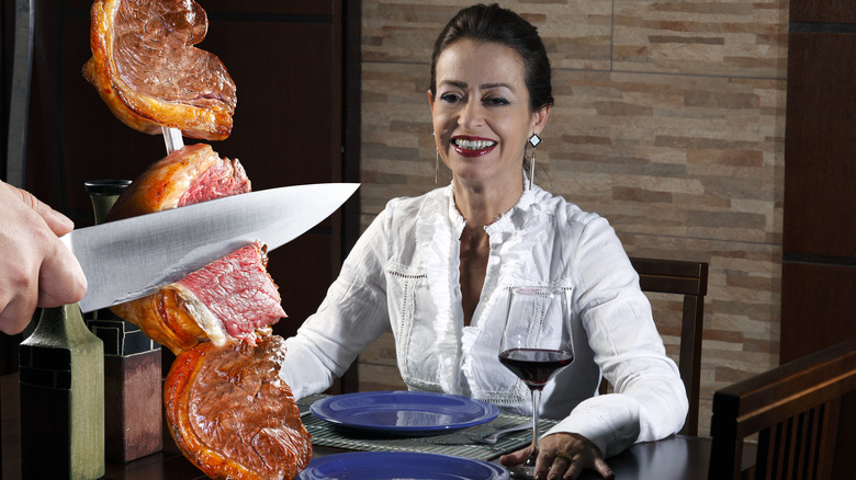 Woman watching meat cut