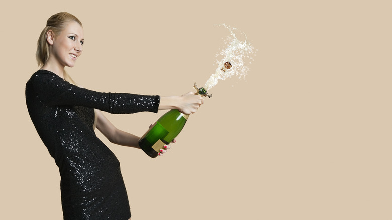 Woman opening a bottle of Champagne