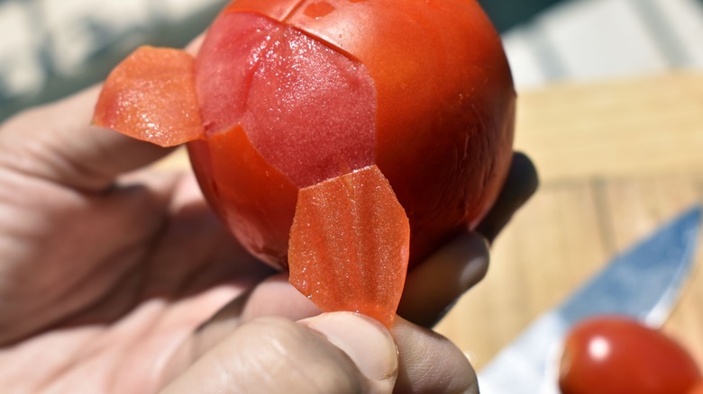 Hand peeling a tomato