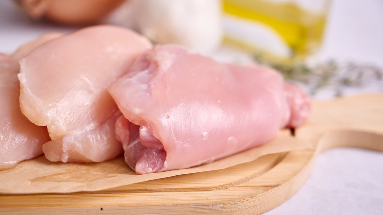 A chicken thigh on a cutting board