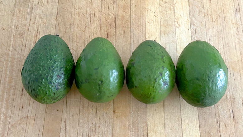 Four unripe avocados