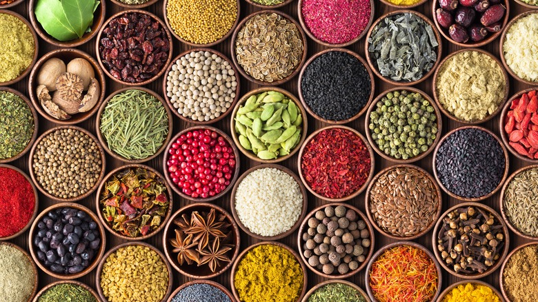 A variety of spices and seasonings separated into individual bowls filling the frame