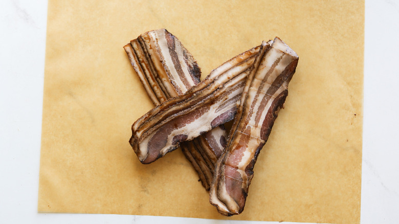 Slices of uncooked cured bacon