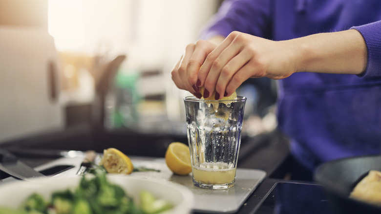 squeezing lemon into a glass