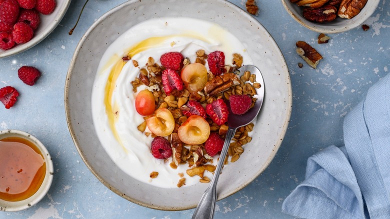 Honey drizzled on Greek yogurt topped with berries and nuts