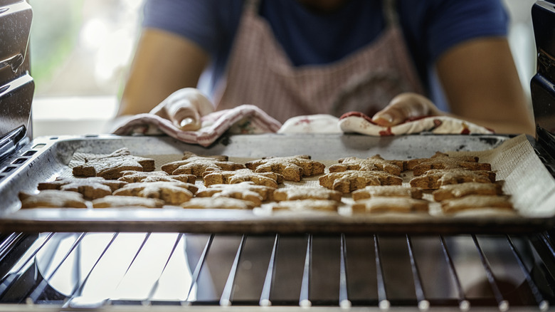 A baking tray of cookies being removed from the oven