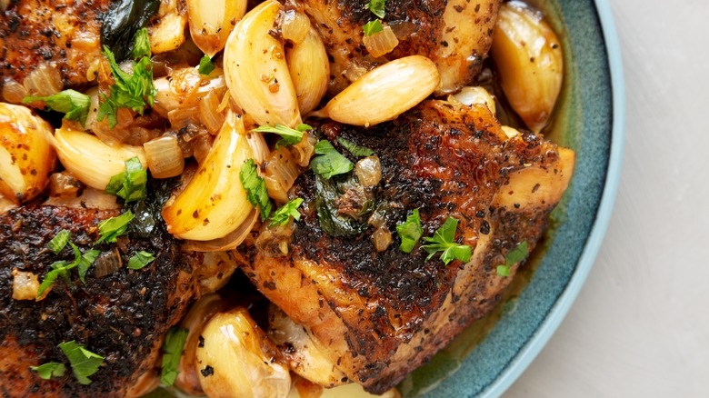 Close up of 40 clove garlic chicken on a blue plate