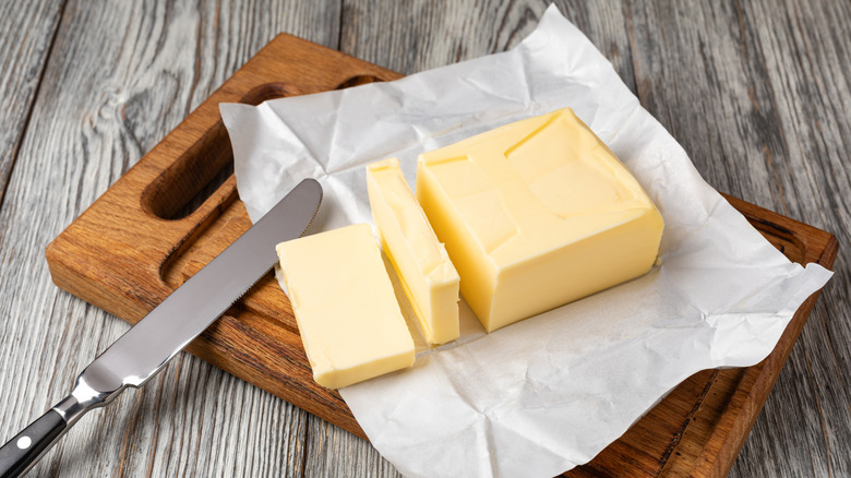 Slices of butter on wooden board