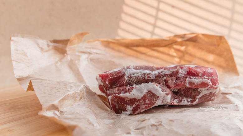 A frozen steak rests on butcher paper.