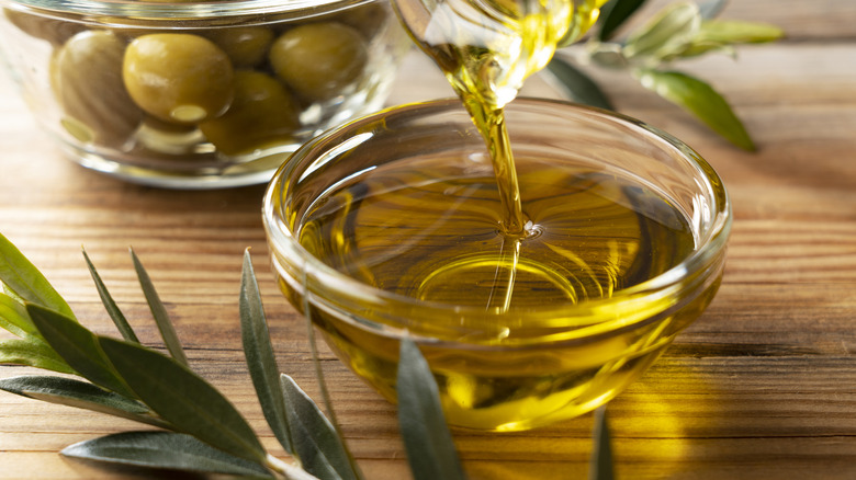 Pouring olive oil into a small glass dish