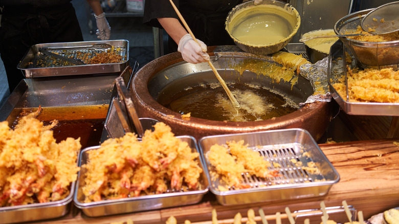 Person frying shrimp tempura