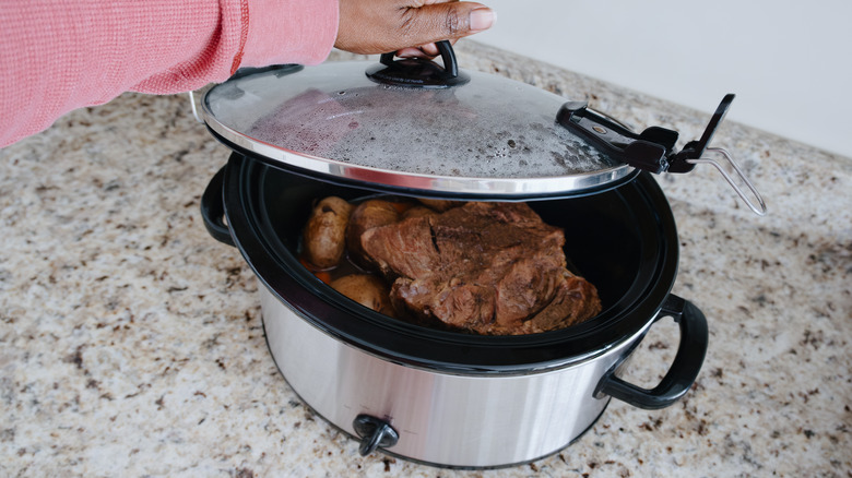 Removing lid from slow cooker full of meat and potatoes