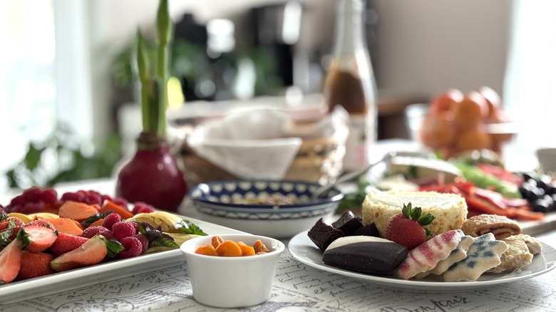 table laid with fruit, cookies, cake, and drinks