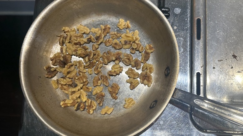 Raw walnuts scattered in dry pan