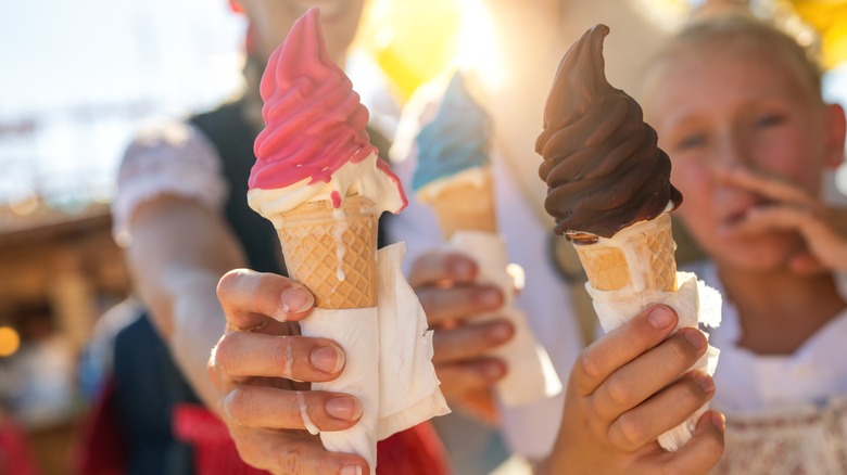 Family holding red, blue and chocolate dipped cones