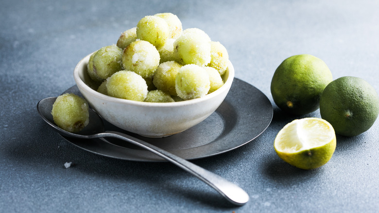 Sour candy grapes in bowl with limes