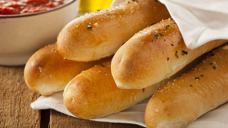 Buttery breadsticks wrapped in white cloth napkin