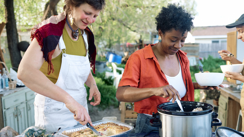 People serving food from slow cooker