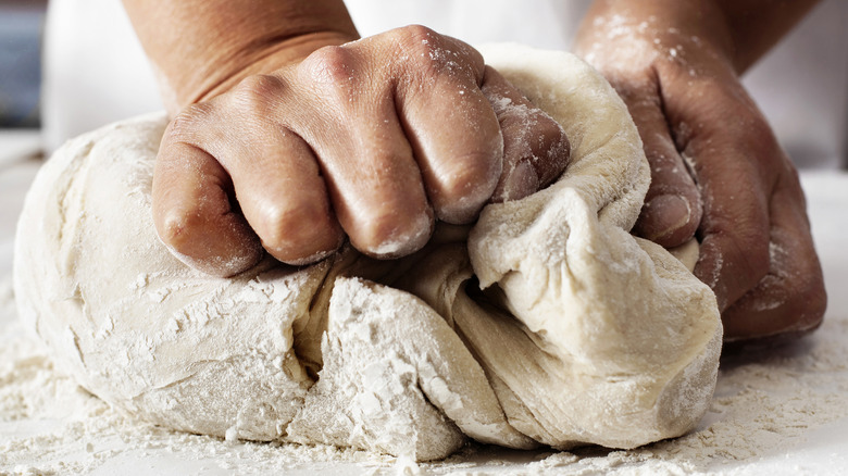 Closeup of person kneading bread dough