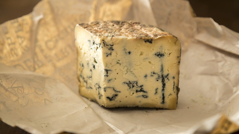 A wedge of blue cheese showing blue veins