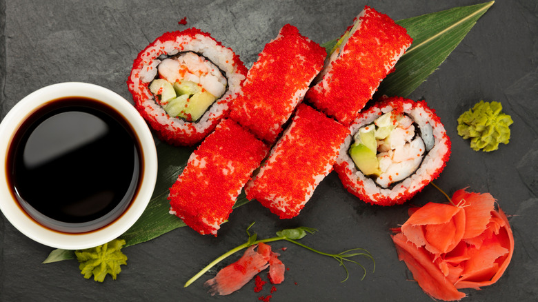 Boston sushi roll covered in fish roe with soy sauce and wasabi