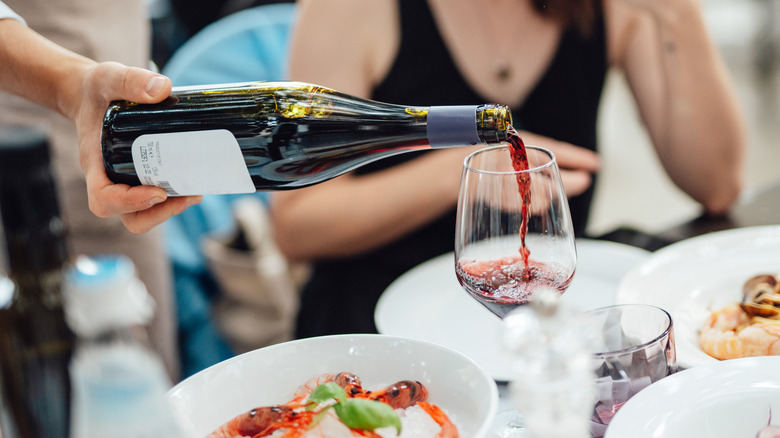 waiter pouring wine while dining out