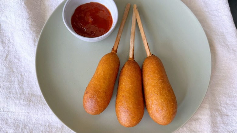 three corn dogs and ketchup