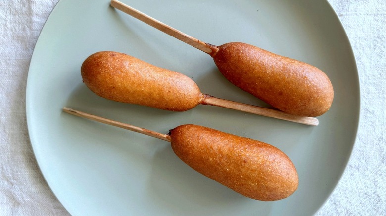 three corn dogs on plate