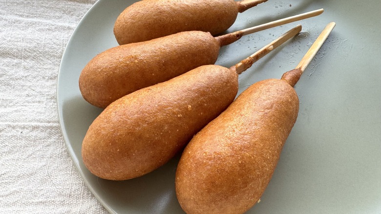 four corn dogs on plate