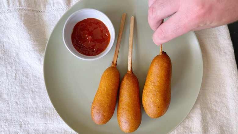 hand grabbing a corn dog