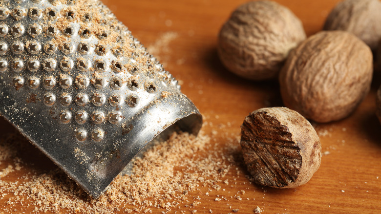 Grated and whole nutmeg next to a grater