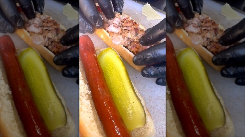 Person assembling Cuban style hot dog